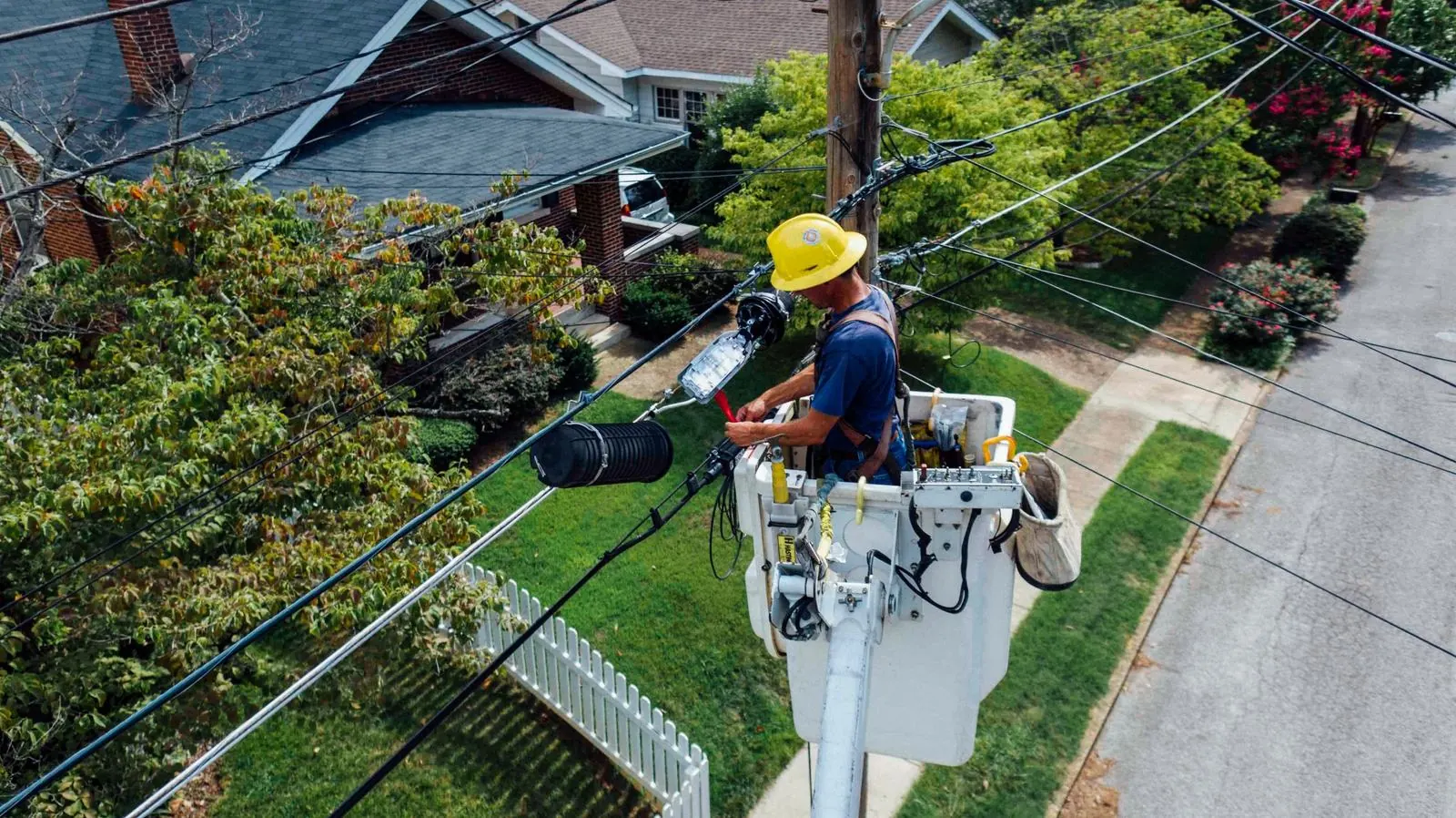 Technician in a bucket truck working on a splice enclosure